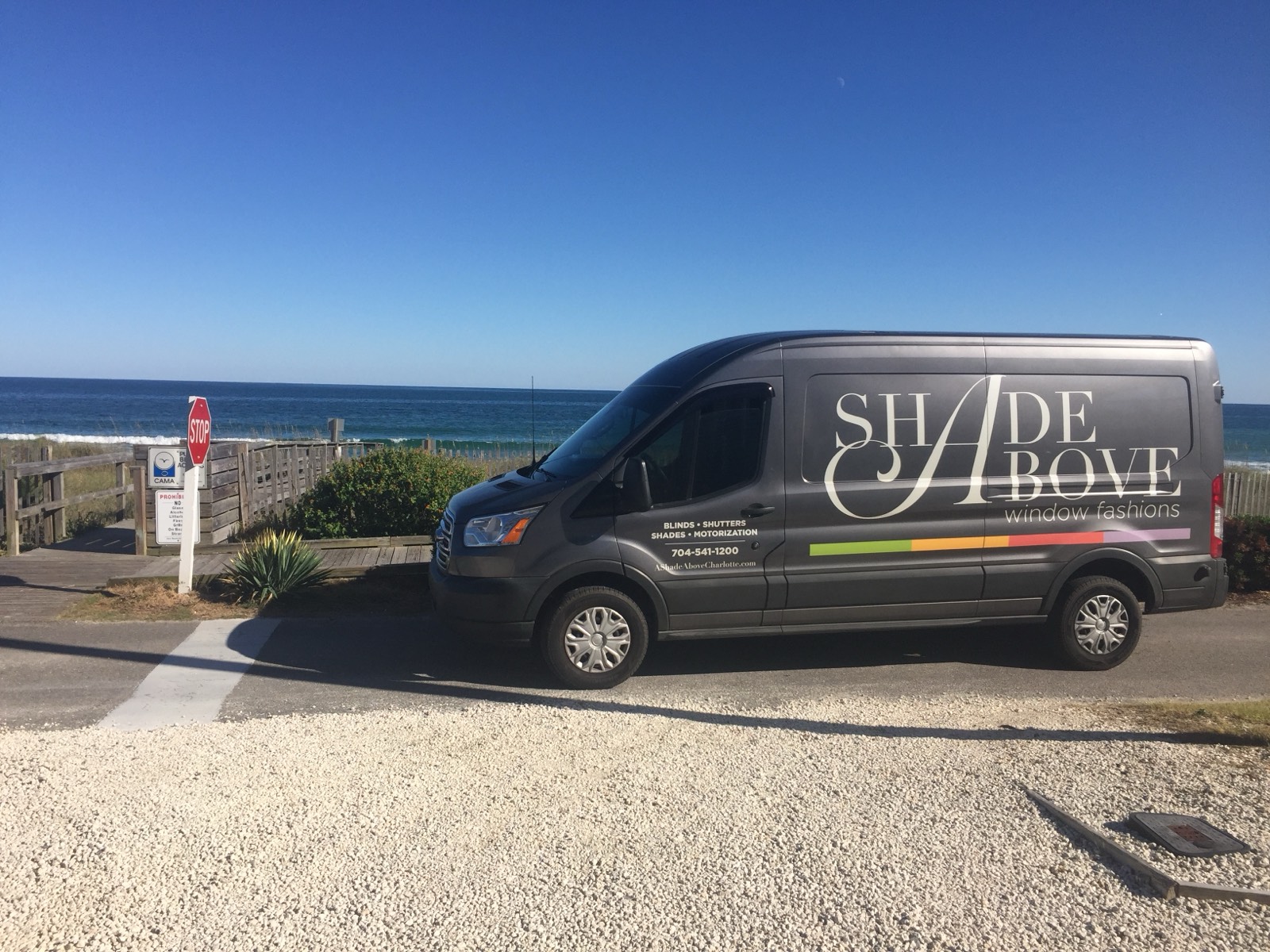 The A Shade Above Coastal van parked at a beach access on the Grand Strand, ocean behind it.