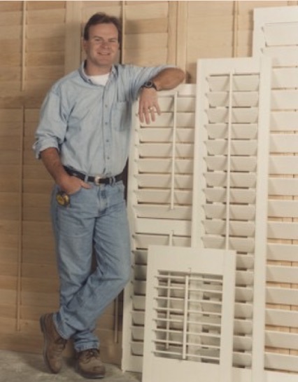 Dalton Taylor in the Artisan Shutter workshop in 1998, leaning against finished plantation shutters.