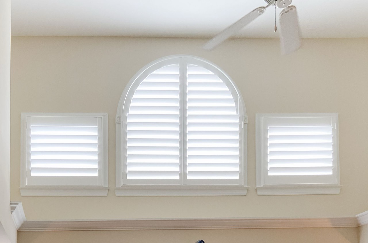 Custom arch-top plantation shutters, center open
