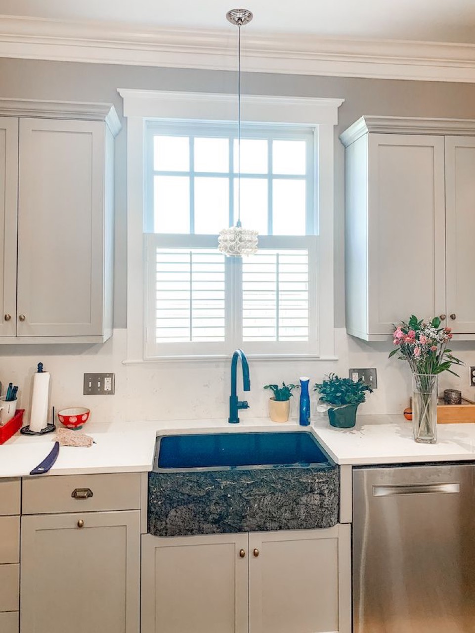 Café-height plantation shutters over a kitchen sink window