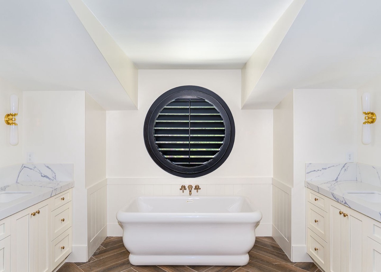 The same round window fitted with a custom round black plantation shutter