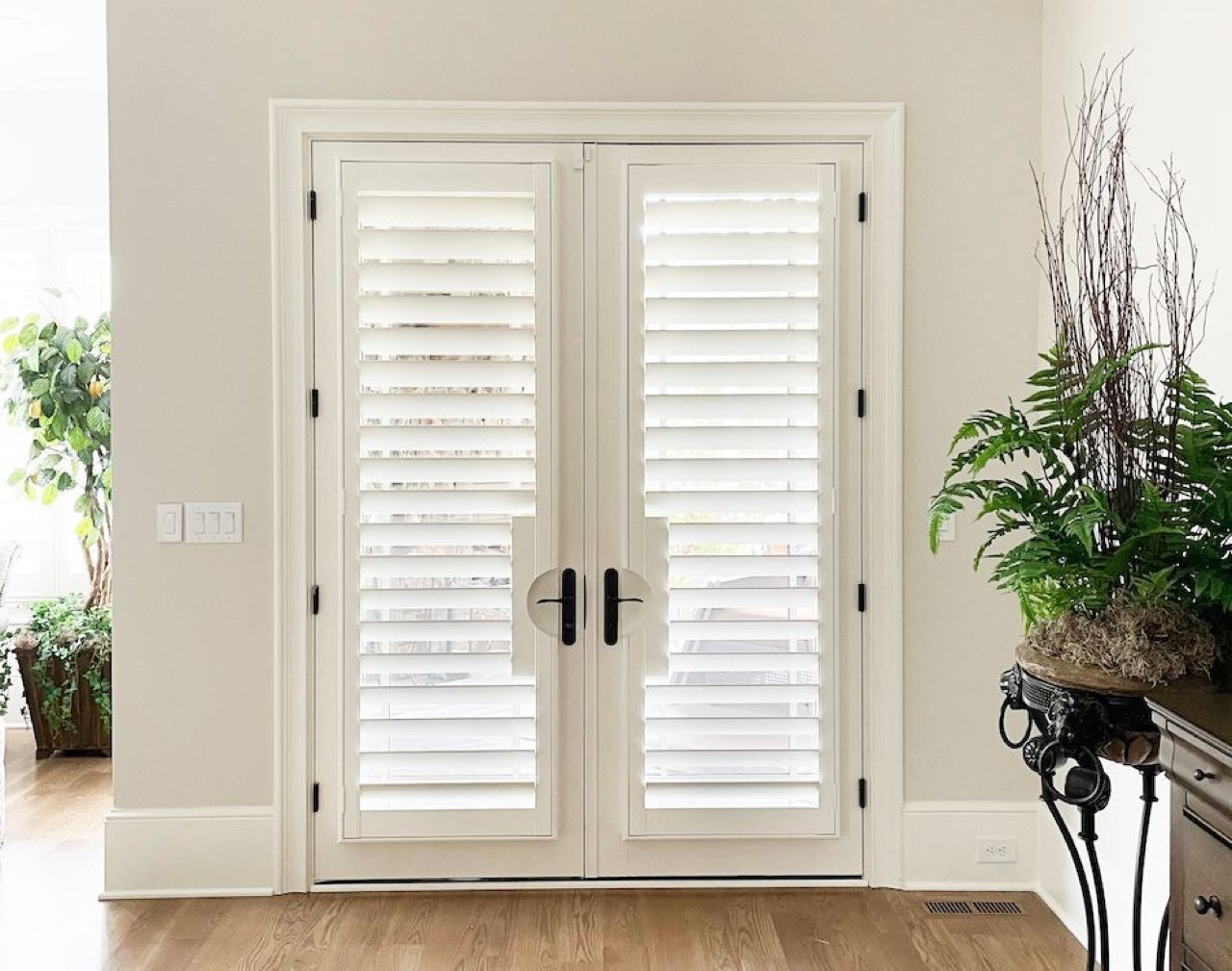 Plantation shutters on French doors with handle cutouts
