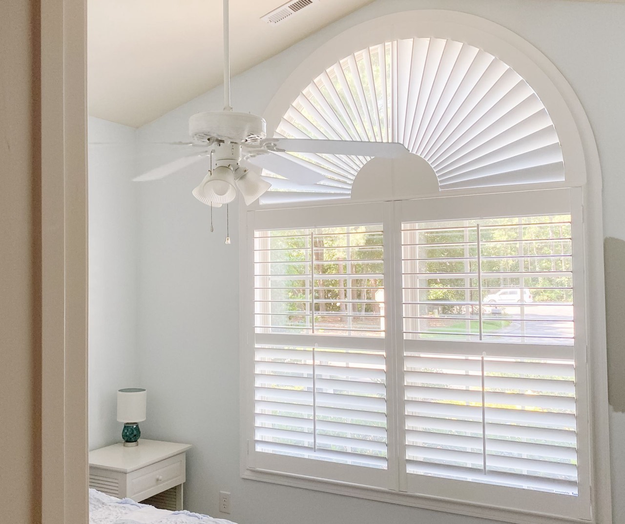Sunburst plantation shutter in a half-round window